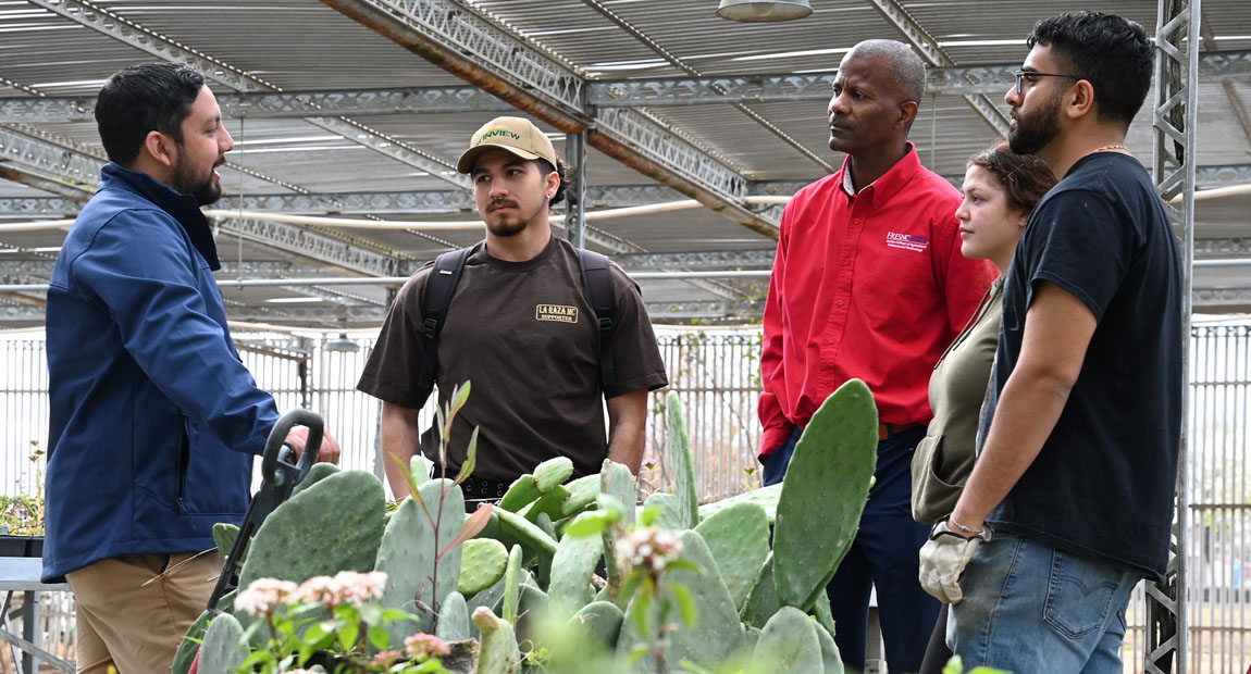 Ernesto Duran with students and Jordan College Dean Rolston St. Hilaire in campus nursery